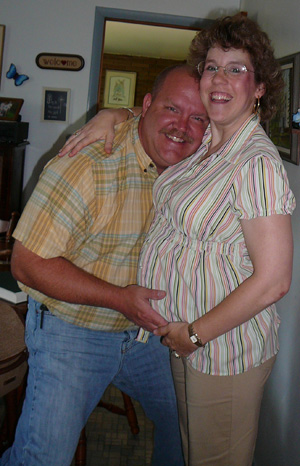 Ginni and her husband are posing together, showing excitement about Ginni’s pregnancy.